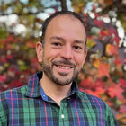 Smiling man in plaid shirt.