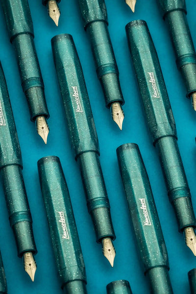 Multiple dark teal fountain pens with gold nibs.