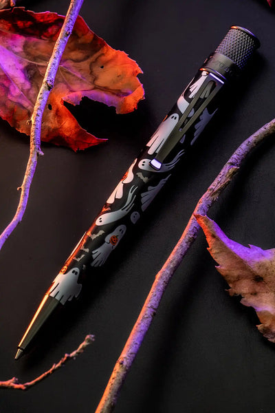 A sleek black pen adorned with playful white ghost illustrations and subtle orange hearts.