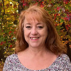 Smiling woman with reddish hair.