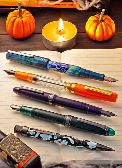 A collection of five decorative fountain pens and a bottle of ink.