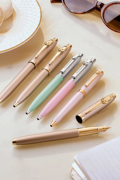 Gold and silver pen set with skull accents.